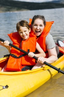 Mother with son (6-7) kayaking on lake