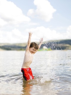 Boy (4-5) jumping in lake