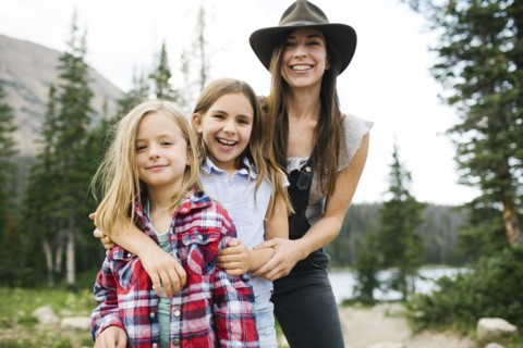Outdoor portrait of mother with kids (6-7, 8-9) in forest