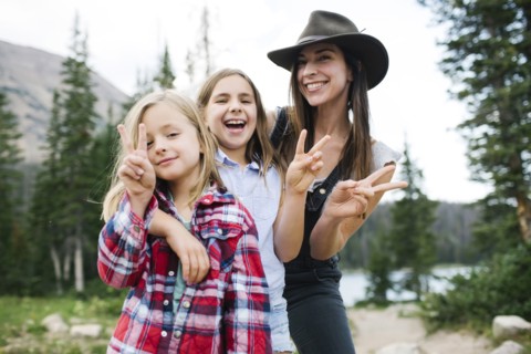Outdoor portrait of mother with kids (6-7, 8-9) in forest