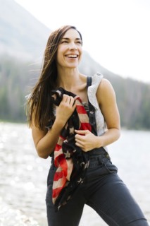 Portrait of woman holding us flag by lake