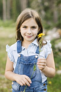 Portrait of girl (8-9) holding wildflowers