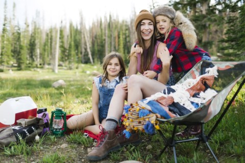 Mother with son (6-7) and daughter (8-9) camping in forest