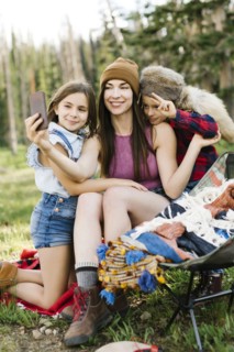 Mother with son (6-7) and daughter (8-9) camping in forest