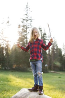 Portrait of boy (6-7) standing on rock in forest
