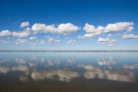 Clouds reflecting in water on sunny day