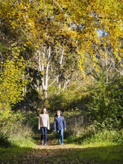 Australia, Queensland, Girls (10-11, 12-13) walking on footpath at autumn