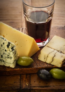 Assorted cheeses with olives and red wine