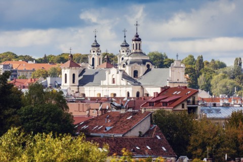 Lithuania, Vilnius, Storm clouds above church and residential buildings