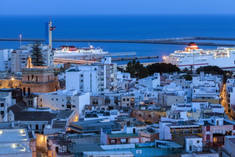 Spain, Andalusia, Almeria, Cityscape with sea at dusk