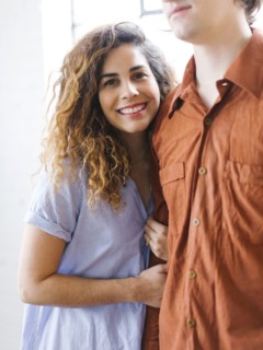 Couple standing against window