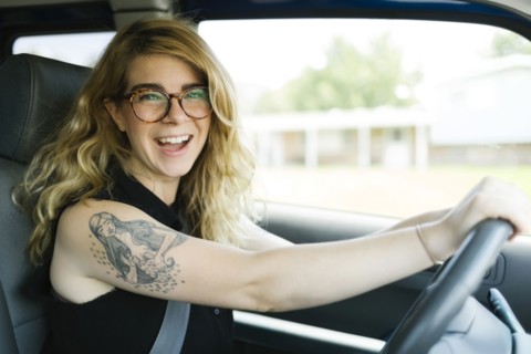 Woman driving car and laughing