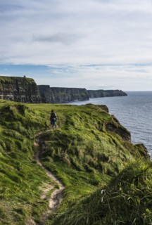Ireland, Clare County, Woman walking along Cliffs of Moher