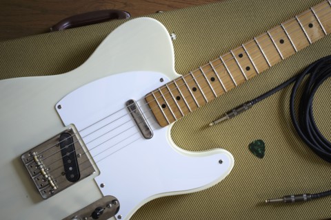 Fender Telecaster and music equipment lying on guitar case