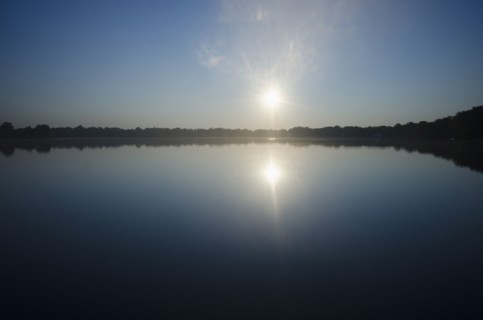 Sun rising above lake