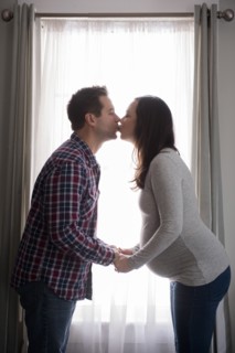 Mid adult couple kissing in front of window