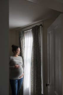Pregnant woman looking through window