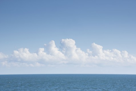 White cumulus clouds above blue Atlantic Ocean