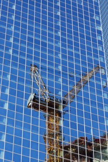 USA, New York, New York City, Crane reflecting in glass wall