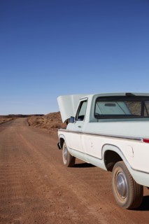 USA, Arizona, Broken pick up truck parked on desert road