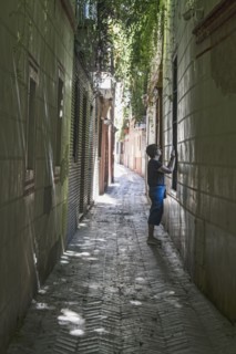 Spain, Seville, Woman taking photo with cell phone in backstreets of Judeira