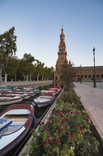 Spain, Andalusia, Seville, Rowboats moored in canal on Plaza de Espana at dawn