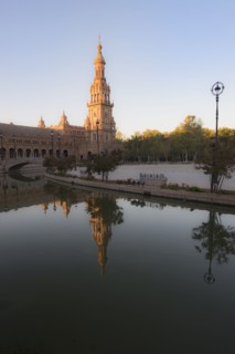 Spain, Andalusia, Seville, Tower in Plaza de Espana reflected in water