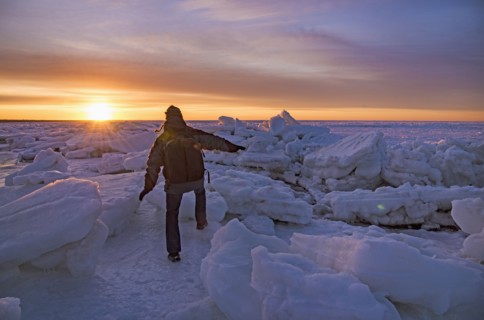 USA, Massachusetts, Cape Cod, Eastham, Man balancing on sea ice at dusk