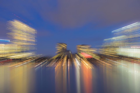 Light trails from city skyline at dusk