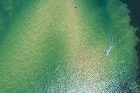 Australia, New South Wales, Narooma, Aerial view of bay and motorboat