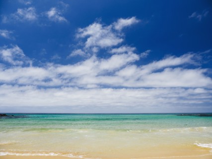 White clouds above sea and sandy beach