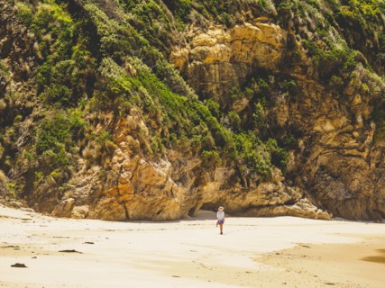 Australia, New South Wales, Bermagui, Woman walking along beach