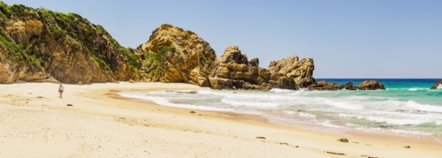 Australia, New South Wales, Bermagui, Woman walking along beach