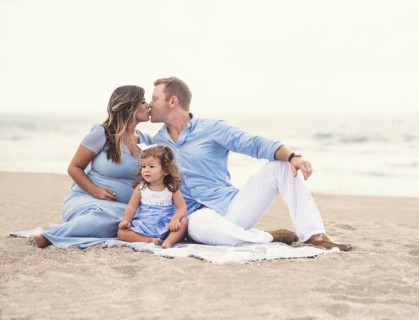 Family sitting on blanket on beach