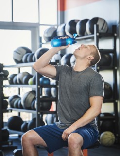 Mid adult man drinking in gym