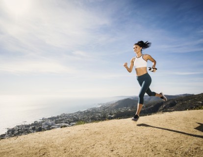 Woman jogging on mountain with water bottle