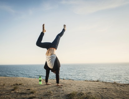 Man doing handstand on beach
