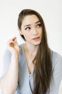 Woman cleaning her ear with cotton bud