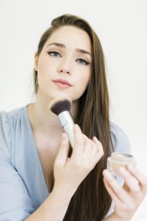 Woman applying make up with brush