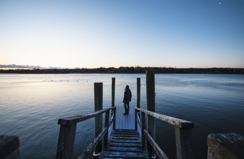 Man standing on pier at dawn