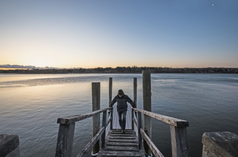 Man standing on pier at dawn