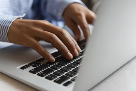 Hands of woman typing on laptop