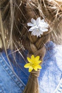 Close up of flowers in girl's braided hair