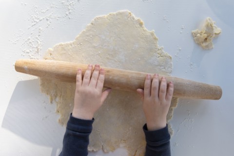 Boy's hands rolling dough