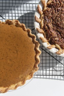Pumpkin and pecan pies on a cooling rack
