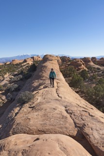 Woman hiking on rock in Arches National Park, Utah, USA
