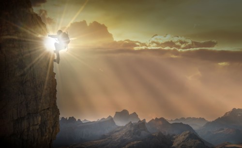 Silhouette of woman rock climbing in the Dolomites at sunrise