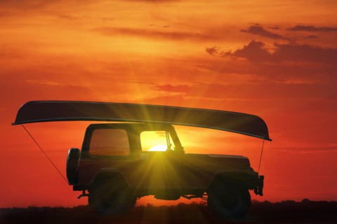 Canoe on top of Jeep at sunset