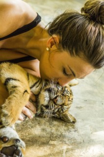 Woman kissing tiger cub