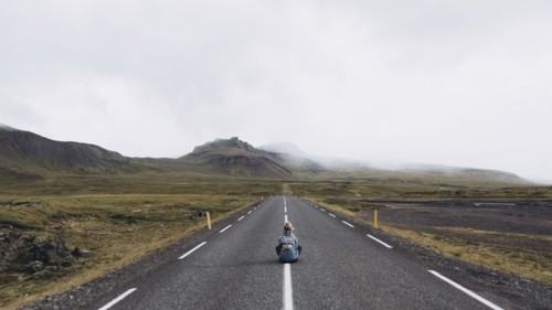 Woman sitting on highway in Iceland